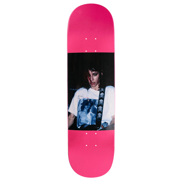 A VIOLET skateboard deck featuring a black and white graphic of Kim Gordon wearing a cross necklace and a t-shirt with a skull design.