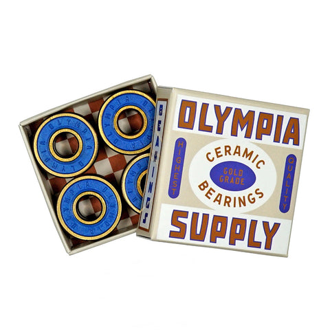 A box of four blue and gold OLYMPIA SUPPLY GOLD GRADE CERAMIC BEARINGS from OLYMPIA, featuring precision ceramic six-ball bearings labeled "Highest Quality.