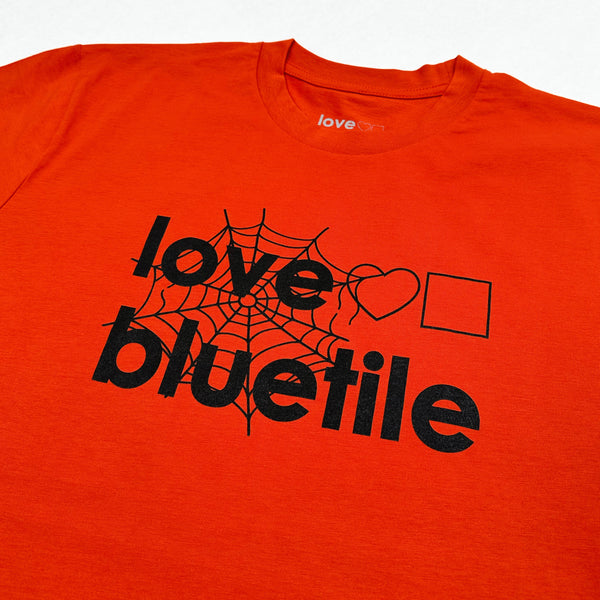 A red BLUETILE "LOVE BLUETILE HALLOWEEN" TEE AUTUMN with Bluetile Skateboards on it.
