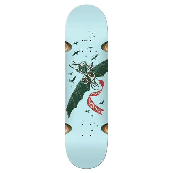 A REAL WILKINS TRANSPORT WHEEL WELLS skateboard with a design of a cyclist on a bat-like creature, surrounded by birds, and the name "Wilkins" in REAL MASON SCRIPT against a light blue background. The 8.531.8" length board features vibrant colorblock accents that make it stand out.