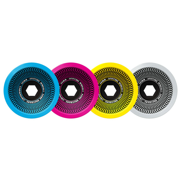 The SPITFIRE 80HD SUPER WIDE 58MM CMYK skateboard wheels come in a set of four, featuring vibrant blue, pink, yellow, and white colors with striking black spiral designs.