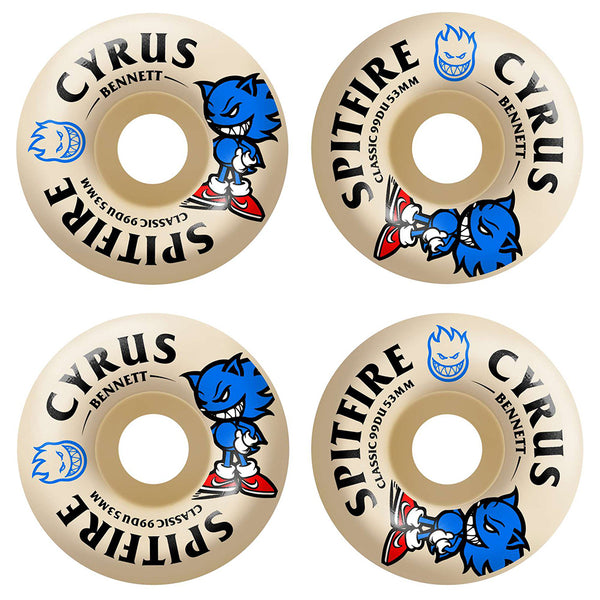 Four beige SPITFIRE skateboard wheels with blue cartoon graphics and "SPITFIRE F4 CYRUS BURN SQUAD CLASSIC 99D 53MM" printed in black and blue, featuring a medium width riding surface for balanced control.