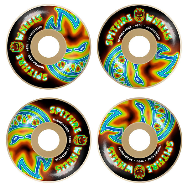 A set of four SPITFIRE F4 RADIOACTIVE CLASSIC BIG HEADS 99D 54MM skateboard wheels by SPITFIRE is displayed from above on a black background, with bold blue, green, and orange flame graphics.