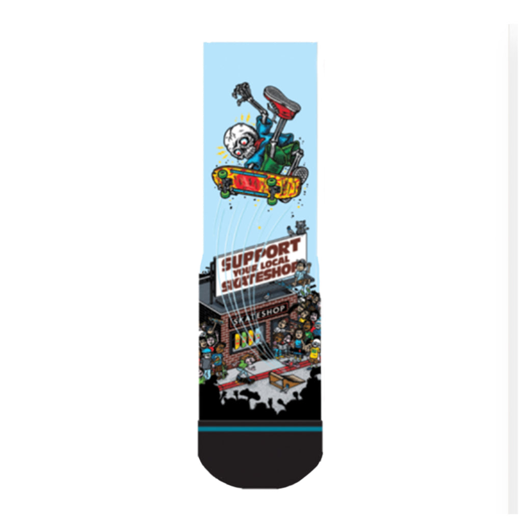 The STANCE X SKATE SHOP DAY LARGE sock by STANCE features an illustrated skateboarder in mid-air above a "Support Your Local Skateshop" sign, with a skateshop and crowd below, made from a cotton blend.