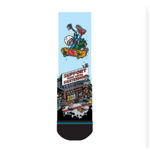 The STANCE X SKATE SHOP DAY LARGE sock by STANCE features an illustrated skateboarder in mid-air above a "Support Your Local Skateshop" sign, with a skateshop and crowd below, made from a cotton blend.