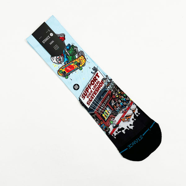 This vibrant sock, "STANCE X SKATE SHOP DAY LARGE," showcases a skateboarder and skate shop scene. Made from a comfy cotton blend, it comes with a "Stance" tag, injecting adventurous flair reminiscent of the Griswold family's spontaneous Christmas vacations into any outfit.