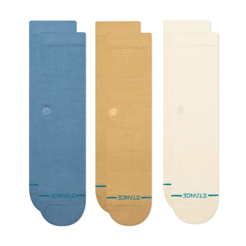 Three pairs of STANCE SOCKS ICON 3 PACK CREAM LARGE in blue, tan, and off-white are laid out vertically side by side, each boasting a small embroidered logo and "STANCE" branding at the toe. These socks offer medium cushioning and arch support for enhanced comfort.