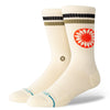 A pair of STANCE SOCKS SUN DIAL CREAM LARGE from STANCE, featuring beige cotton crew socks with ribbed cuffs, black and olive green stripes at the top, and a red-and-white circular pattern on the sides. The toe area has small blue text, providing both style and arch support.