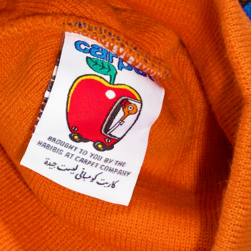 A close up of a Carpet Co. CARPET NO FOLD BEANIE ORANGE with a label on it.