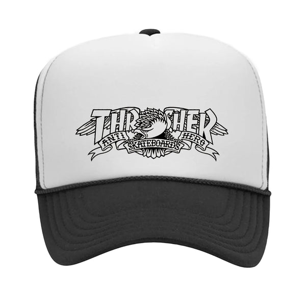 White and black trucker hat featuring the "Thrasher" logo with an eagle graphic holding scrolls that read "Anti-Hero" and "Skateboards." This snapback also highlights classic Antihero artwork, perfect for any skater. The product name is THRASHER x ANTI HERO MAG BANNER TRUCKER HAT BLACK / WHITE from the brand THRASHER.