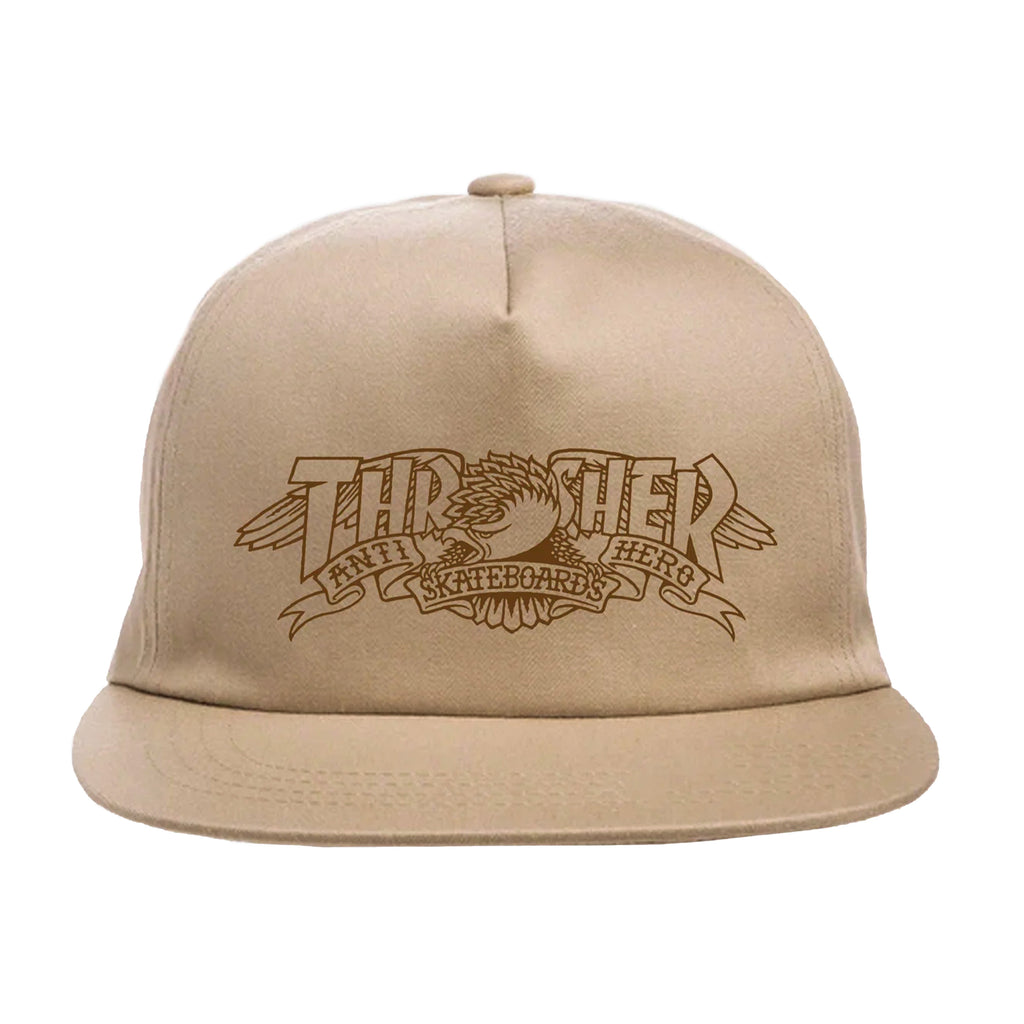 THRASHER x ANTI HERO MAG BANNER SNAPBACK HAT KHAKI with a flat brim featuring a brown "Thrasher Skateboard" logo on the front, including a graphic of an eagle holding a ribbon with the same text.