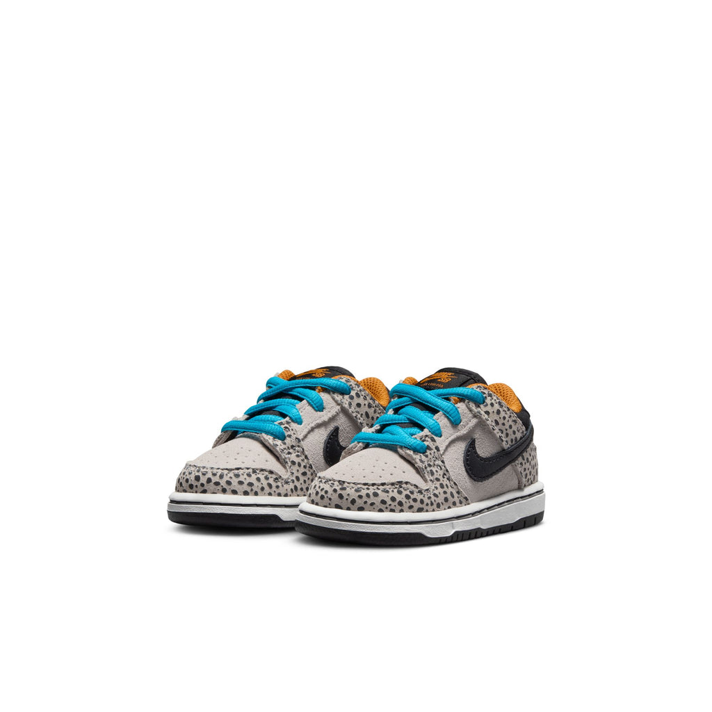 A pair of toddler shoes in a stylish leopard print with blue laces, black Nike swooshes, and orange interior lining, displayed against a white background. These Nike SB Dunk Low Pro Electric TD Phantom/Black sneakers are perfect for little ones on the go.