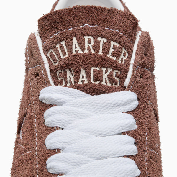 A limited-edition CONVERSE x QUARTER SNACKS ONE STAR PRO DARK CLOVE skate shoe in brown and white with the words quarter snacks on it.