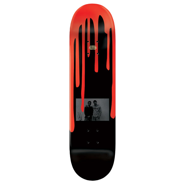 A ZERO skateboard deck with a red and black design featuring a grayscale photo of two people near the center, branded as a "Leo Romero Guest Board.