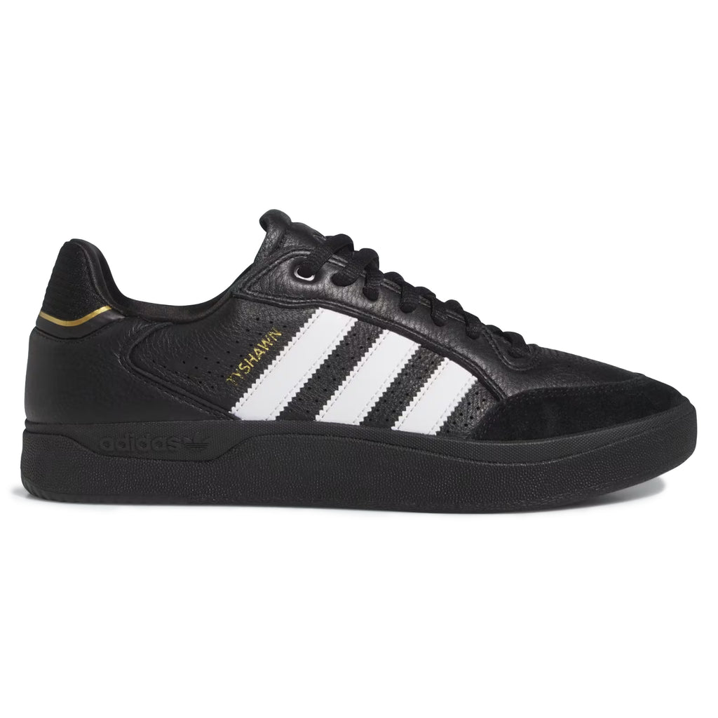 The ADIDAS TYSHAWN LOW in Core Black, Cloud White, and Gold Metallic boasts iconic white stripes, gold accents, and Adiprene cushioning for exceptional comfort.