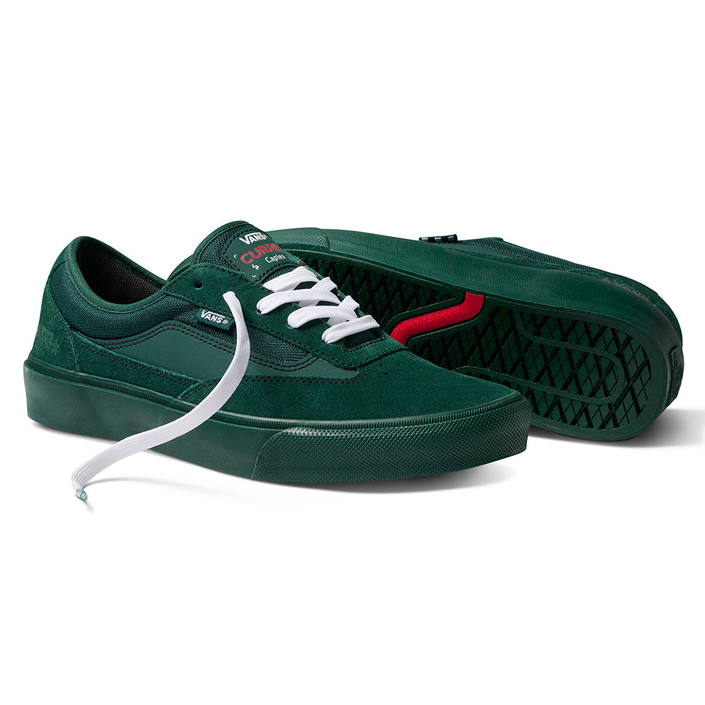 The VANS X ATIBA SKATE CURREN CAPLES EMERALD shoes by VANS feature a dark green design with white laces; one shoe stands upright, the other lies on its side exposing the black and red sole crafted for comfort and performance.