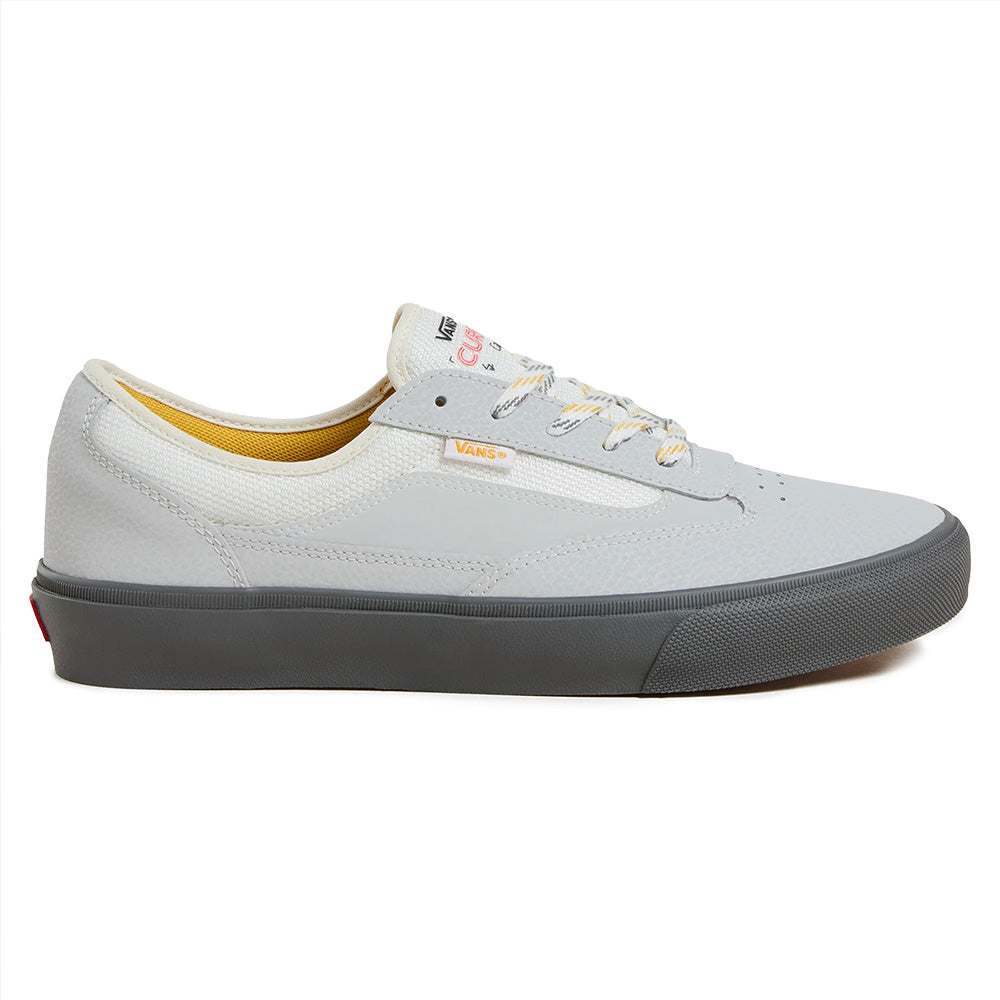 The VANS SKATE CURREN CAPLES GREY is a light gray low-top sneaker featuring white laces, yellow inner lining, a dark gray rubber sole, and POPCUSH insoles for enhanced comfort, shown in side profile.