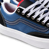 Close-up of a VANS SKATE OLD SKOOL 36+ sneaker, featuring navy and red color with white laces, stitching, metal eyelets, and a red interior lining. Enhanced with Vans DURACAP for durability.