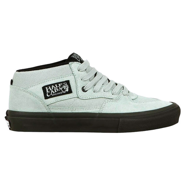The VANS SKATE HALF CAB GREY OLIVE / BLACK features a light grey upper, black sole and laces, plus a black and white "Half Cab" label—designed by VANS as durable skateboarding shoes for top performance.