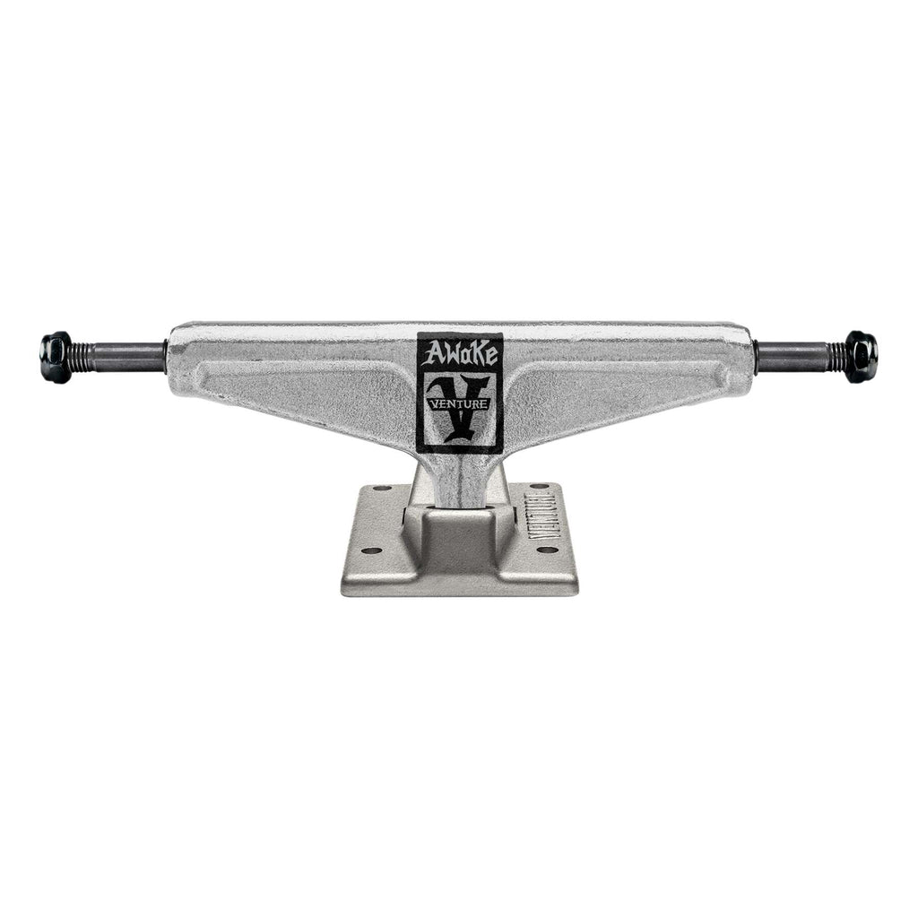 A silver VENTURE MATTHEWS AWAKE LTD 5.6 skateboard truck boasts a polished hanger with a sleek black logo and lettering, paired with an intricate baseplate pattern.