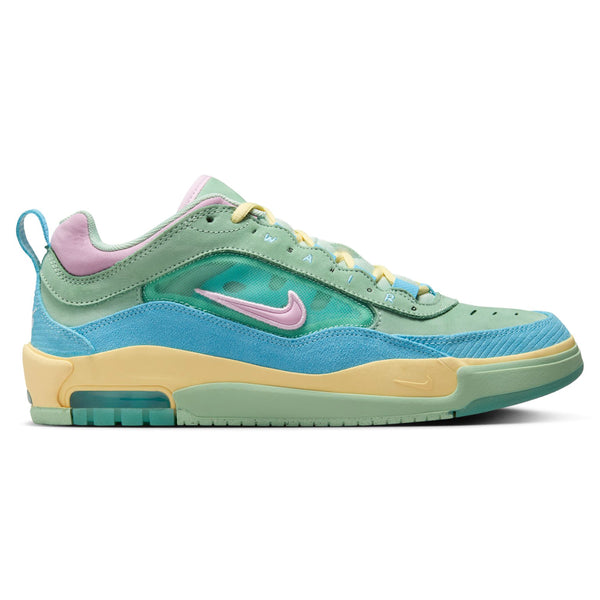 The NIKE SB Ishod 2 Verdy Air Max Blue Gaze / Lt Arctic Pink-Enamel Green is a low-cut athletic shoe featuring a teal and light blue base, pink and yellow accents, a light green midsole, and a rubber outsole with the Nike logo on the side. The shoe incorporates Max Air technology for added comfort and is reminiscent of the NIKE SB Ishod 2 collection.