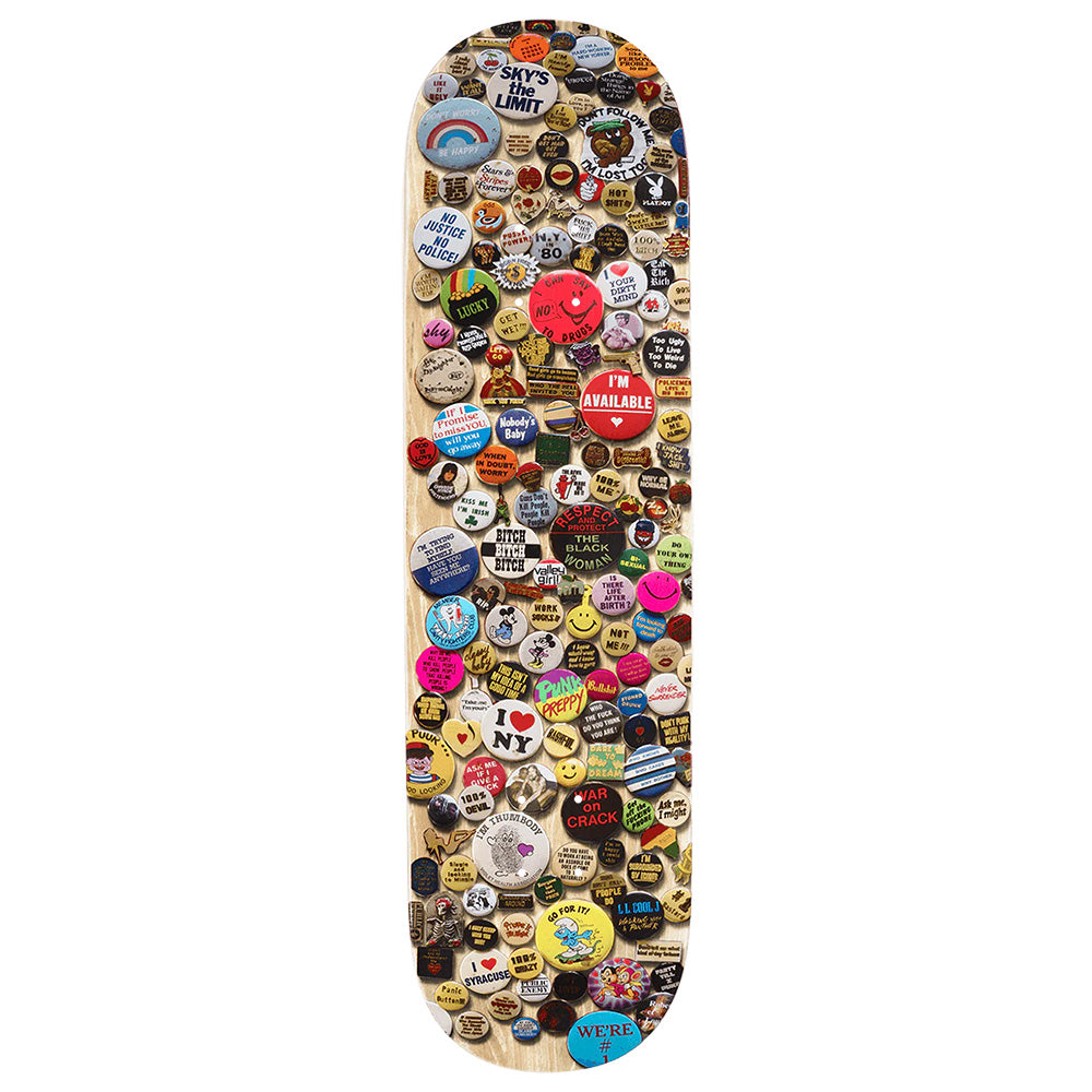 A skateboard deck adorned with vibrant pin-back buttons, featuring exclusive VIOLET PINS NATURAL by violet, each displaying unique William Strobeck-inspired images and slogans.