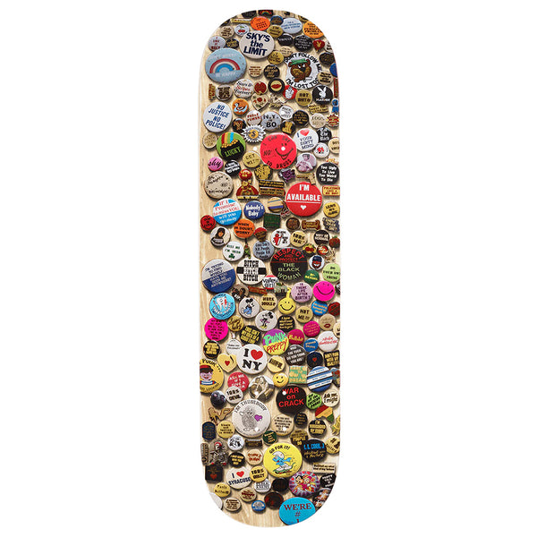 A skateboard deck adorned with vibrant pin-back buttons, featuring exclusive VIOLET PINS NATURAL by violet, each displaying unique William Strobeck-inspired images and slogans.