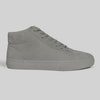 A side view of the CHAPTER MID | STONE FG NUBUCK high-top sneaker by WARSAW LTD highlights its skate-inspired style, featuring grey nubuck and laces against a plain light background.