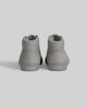 A pair of light gray CHAPTER MID | STONE FG NUBUCK high-tops by WARSAW LTD, viewed from the back with "WARSAW" on each heel—skate-inspired sneakers designed for style and comfort.