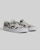 The STRANGER SLIP-ON | TEMPLETON COLLAGE by WARSAW LTD are limited edition white slip-on sneakers with black abstract and graphic prints showcasing Templeton signature artwork, displayed on a light gray background.
