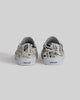 The STRANGER SLIP-ON | TEMPLETON COLLAGE by WARSAW LTD is a limited edition pair of canvas slip-ons with black abstract artwork and "WAR SAW" on the heel tabs, featuring Templeton's signature style.
