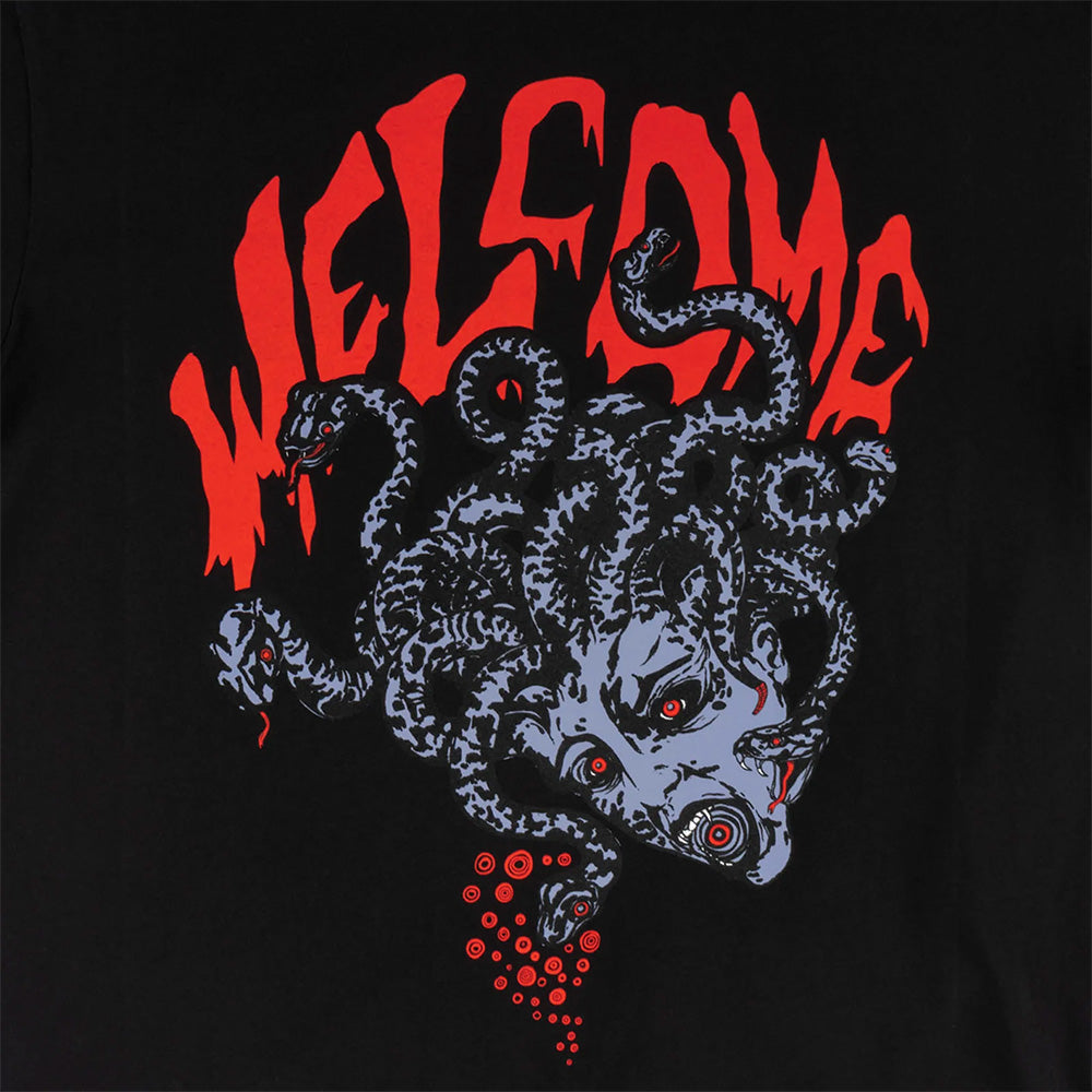 The WELCOME MEDUSA BOXY GARMENT-DYED TEE BLACK features a screen-printed Medusa head graphic with snakes for hair beneath the red, drippy "WELCOME" logo on a black background.