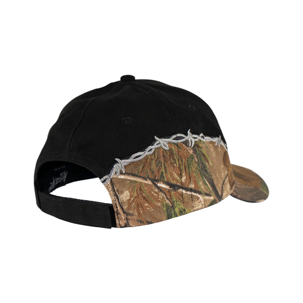 The WELCOME SPLINTER HAT BLACK by WELCOME features a camouflage-patterned front and bill, black mesh back, and decorative white stitching along the seam.
