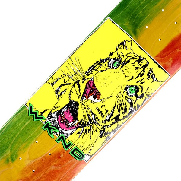 The WKND TIGER TIE-DYE skateboard deck by WKND features a tie-dye background with a tiger face graphic, bold green "WKND" lettering, and puffy paint-inspired accents.