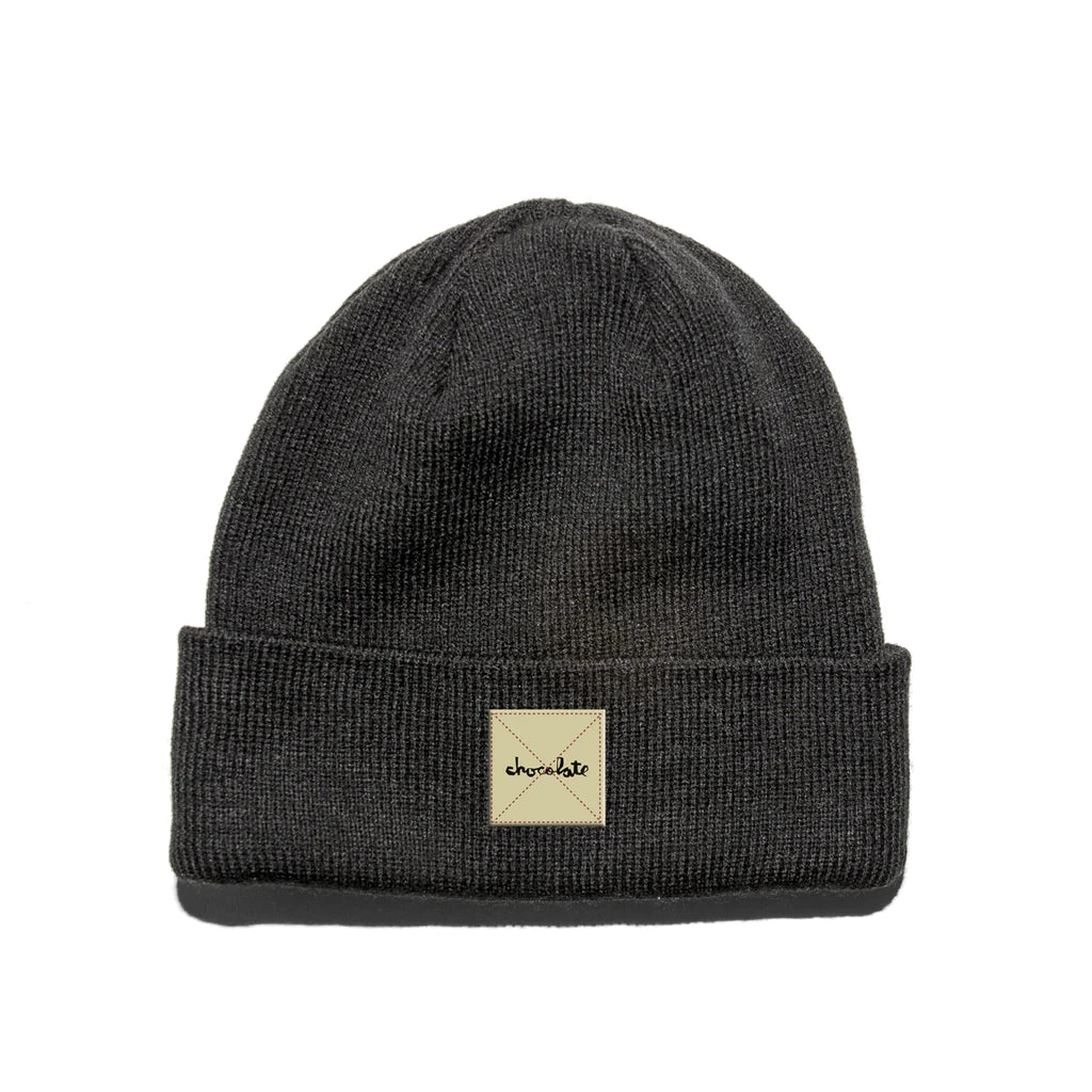 A CHOCOLATE black beanie with a patch on it.