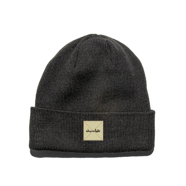 A CHOCOLATE black beanie with a patch on it.