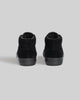 A pair of WARSAW LTD CHAPTER MID | BLACK / BLACK pig suede high-top sneakers, shown from the back against a plain gray background, designed for comfort and durability.