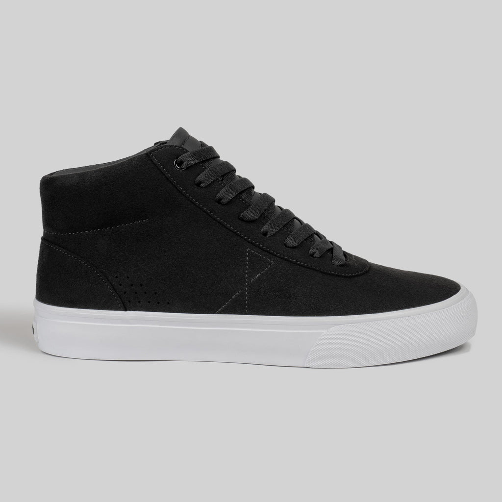 The CHAPTER MID | BLACK / WHITE SYNTHETIC by WARSAW LTD is a black high-top sneaker with black laces, a white rubber sole, and premium synthetic suede, shown on a plain gray background.