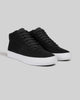 A pair of WARSAW LTD CHAPTER MID high-top sneakers in black synthetic suede with white rubber soles and black laces, displayed on a plain light gray background.
