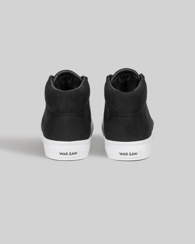 The CHAPTER MID | BLACK / WHITE SYNTHETIC by WARSAW LTD are black high-top sneakers with white soles, "WAR SAW" on the heels, and premium synthetic suede for a skate-inspired style.