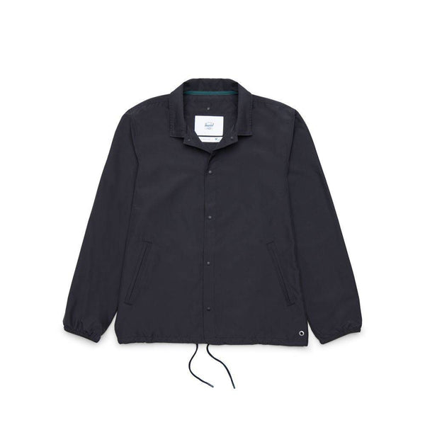 The HERSCHEL SUPPLY CO VOYAGE COACH BLK jacket by HERSCHEL, made from water-resistant ripstop, features a collar, front pockets, elastic cuffs, and a drawstring hem; shown laid flat on a white background.