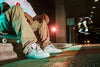 A mid top skateboarder sitting on a ledge at night, wearing ES X DGK ACCEL MID SLIM GREY / CORAL / BLUE shoes.