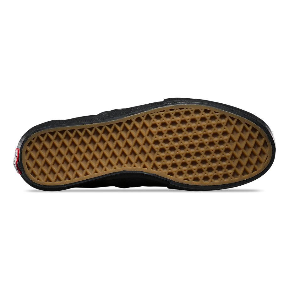 the brown bottom sole of a black slip on shoe