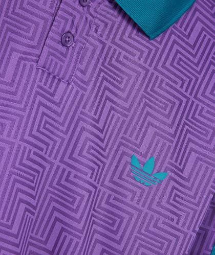 Close-up of the ADIDAS Paradigm Jersey in Active Purple and Black, showcasing a geometric pattern with a green and aqua logo featuring three leaves, reminiscent of an ADIDAS design.