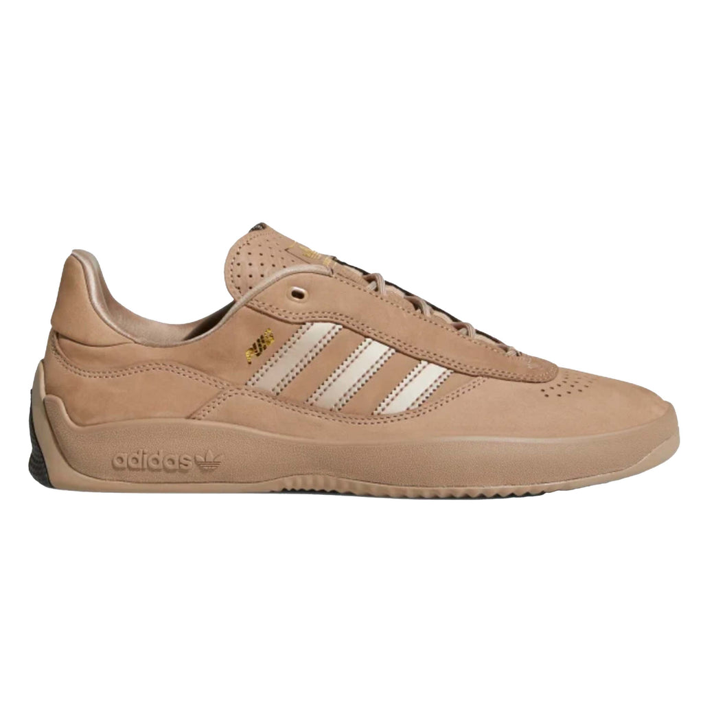 A pair of ADIDAS PUIG CHALKY BROWN / CORE BLACK sneakers.