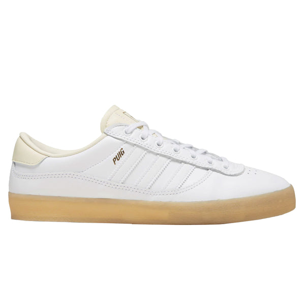 A pair of white Adidas Puig Indoor sneakers with gum soles.