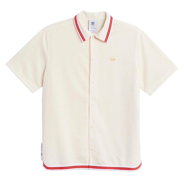 The ADIDAS TJ Warm Up Shirt in white/scarlet features short sleeves, a collar, red and white trim, button front, and gold Adidas logo on the left chest. It’s made from recycled materials for sustainable style.