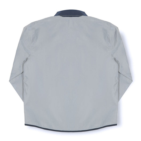The back view of a grey and navy ADIDAS X BLONDEY JOUSTING JACKET SILVER METALLIC.