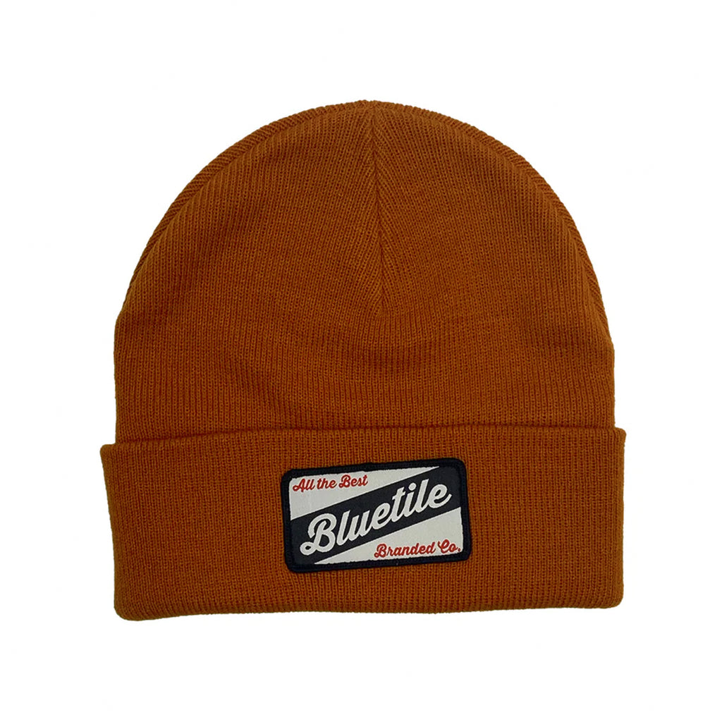 A brown BLUETILE CRAFT PATCH BEANIE AUTUMN with the word bluelie on it, perfect for autumn. Manufactured by Bluetile Skateboards.