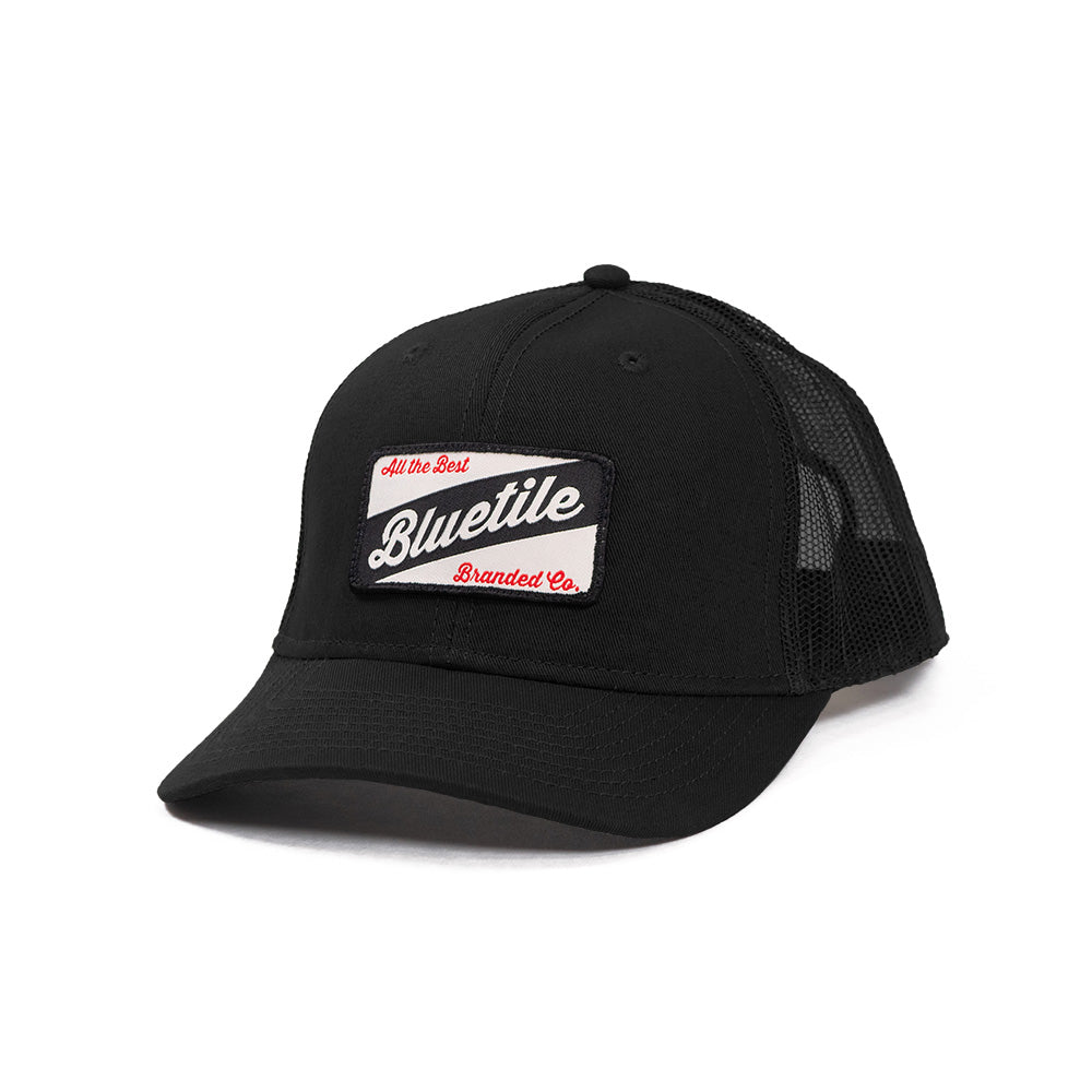 A BLUETILE CRAFT PATCH TRUCKER BLACK hat with a craft patch on it, made by Bluetile Skateboards.